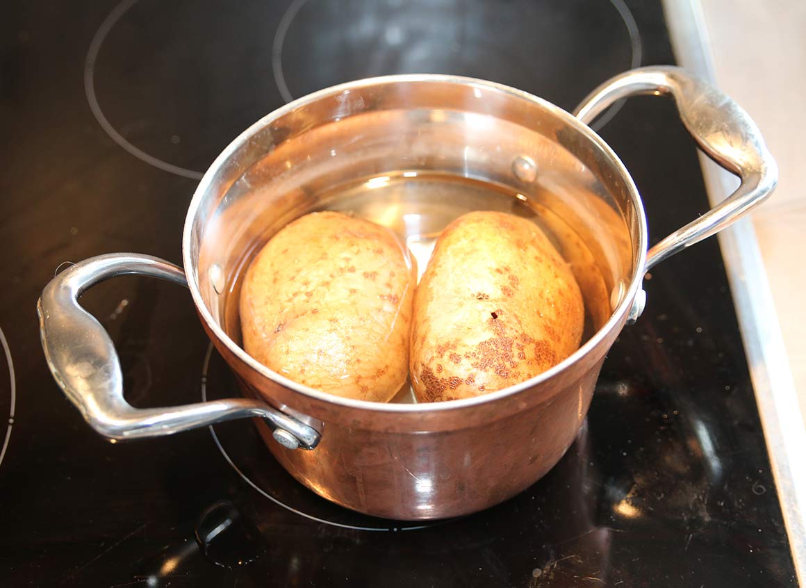 In der Zwischenzeit die Kartoffeln in einem Topf mit Wasser vorgaren (ca. 30 Minuten).