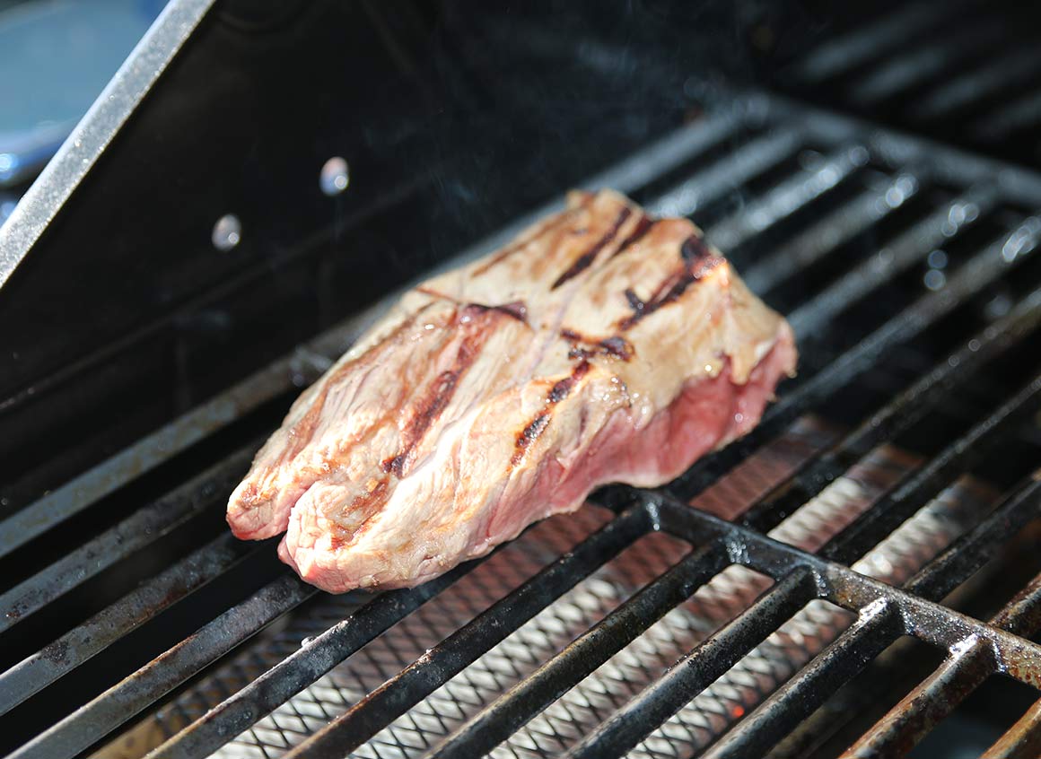 Das Steak von jeder Seite eine Minute (Stoppuhr stellen) scharf anbraten (direkte Hitze).