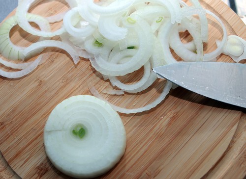 Zwiebel schälen und in Ringe schneiden.